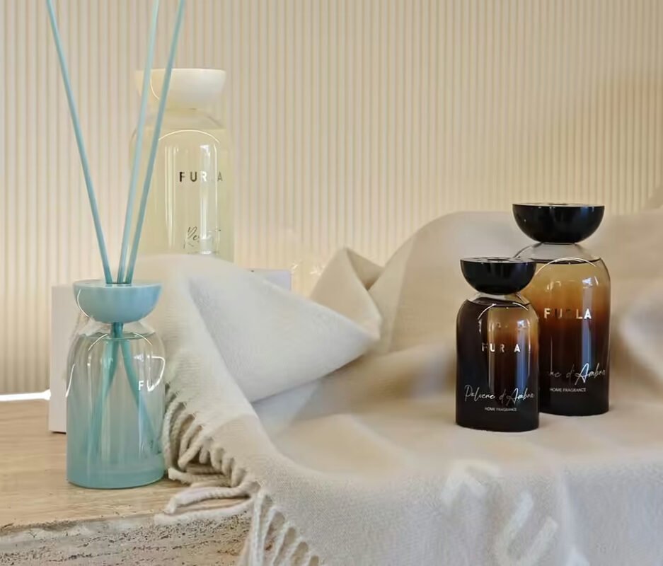 Furla Casa home fragrance diffusers and a wool plaid on a stone ledge